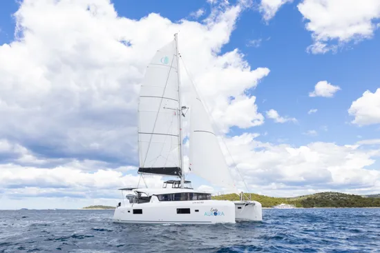 View of Lady Aurora catamaran sailing steadily on calm blue waters